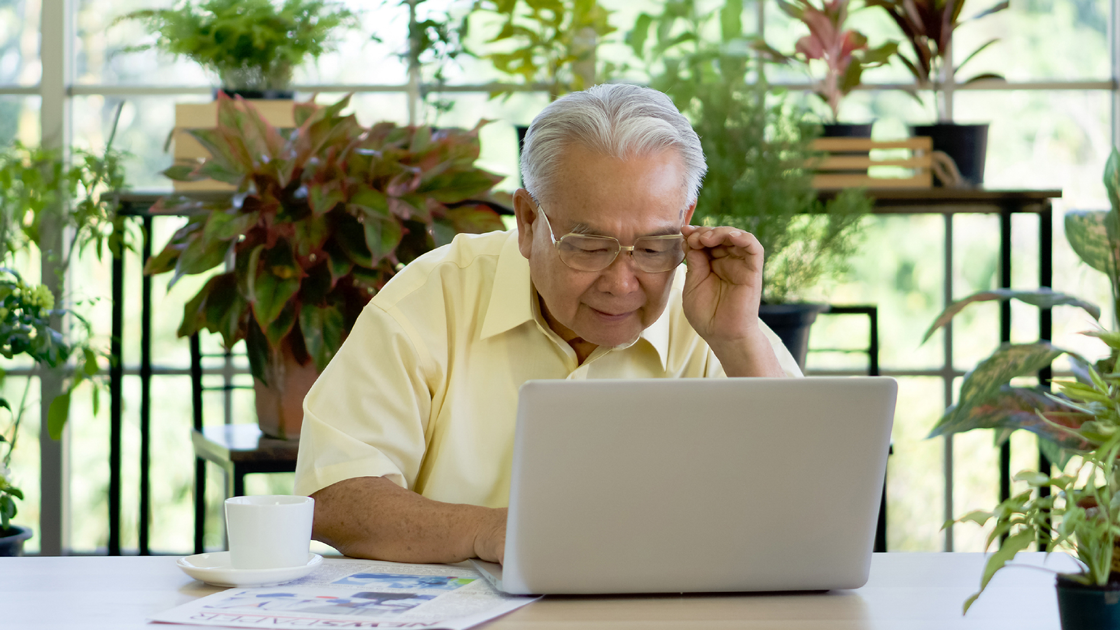 decorative image of a senior man in front of a laptop