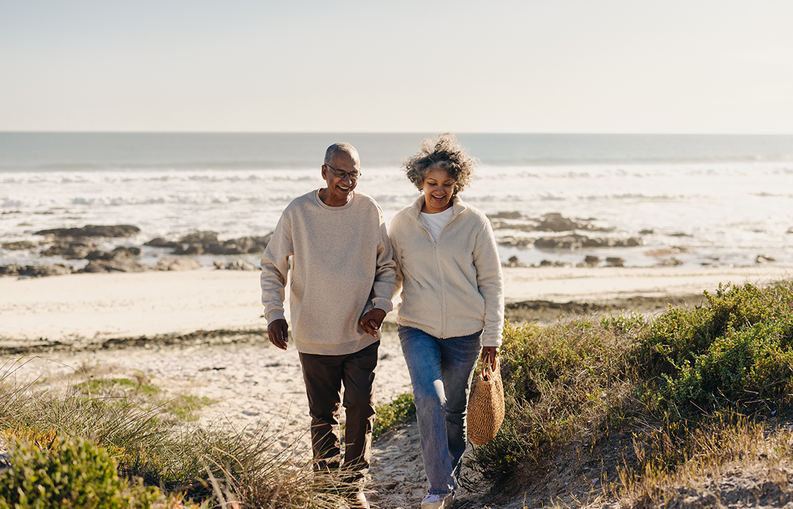 senior couple walking on the beach on a cooler day